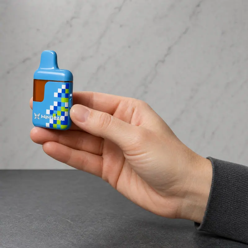 Hand holding a WINDBAR D95 Microvolt in Cool Blue Pixel in front of marble