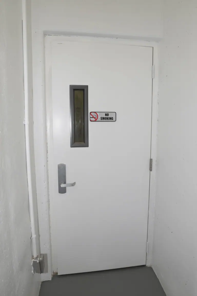 White door with a NO SMOKING sign beside a narrow window — WindBar.ai D91 Voyagers