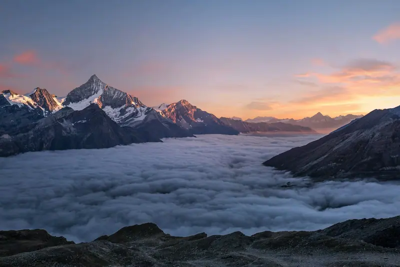 Mountain silhouette with rim light (Unsplash stock) — WindBar.ai D91 Voyagers