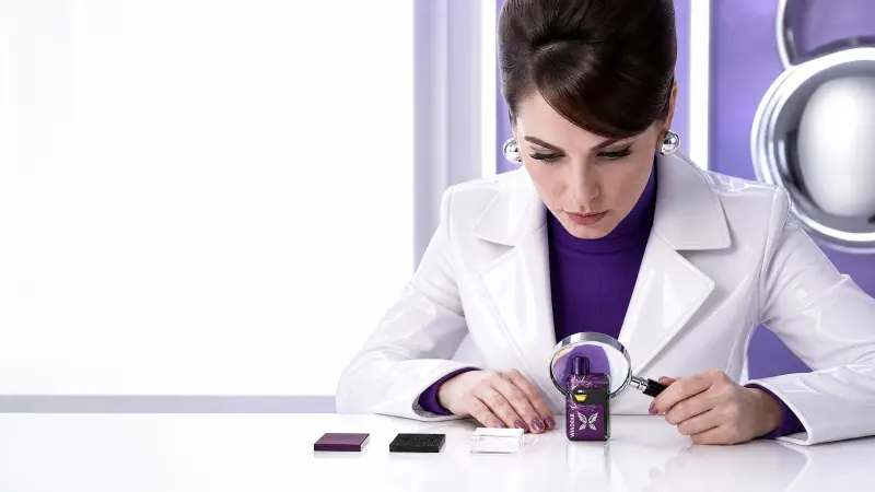 Adult inspector examining a WINDBAR SPECTRUM in Violet Cut with a magnifier (WindBar.ai)